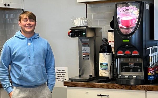 Trojan Grounds staff member Talon Boeve stands beside some of the new coffee shop equipment.